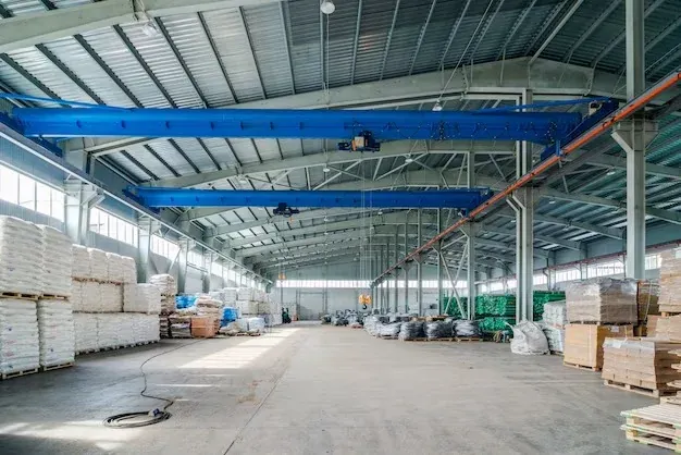 Warehouse interior with palletised stock and an overhead travelling crane